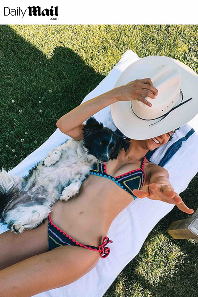 DAILYMAIL: NINA DOBREV SHOWS OFF FLAWLESS BIKINI BODY AS SHE CUDDLES WITH HER DOG WHILE TANNING IN THE BACKYARD